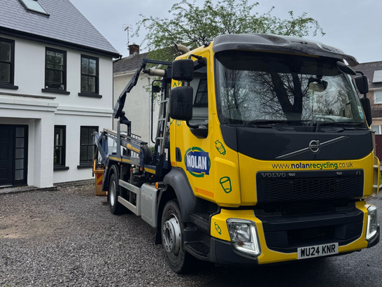 Nolan Recycling Ltd Small Skip lorry delivering a skip to a house in Porthcawl